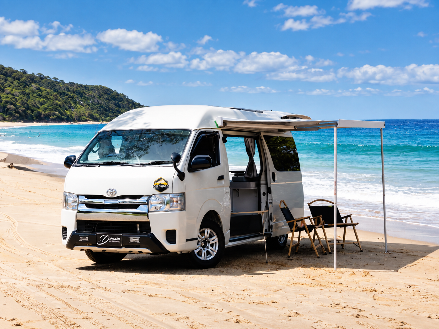 Prebuilt Toyota Hiace campervan beside the beach with its awning extended
